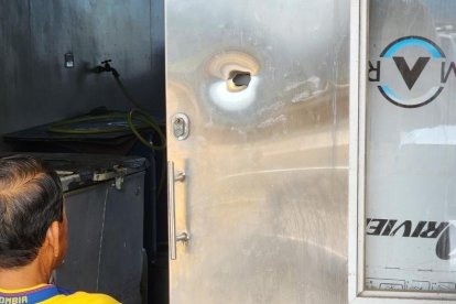 En la puerta de esta bodega están las huellas de los proyectiles disparados.