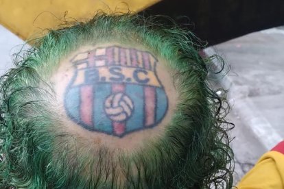El pelo rizado y teñido de verde es el césped y la ‘pelada’ de su cabeza con todo y tatuaje es el estadio.
