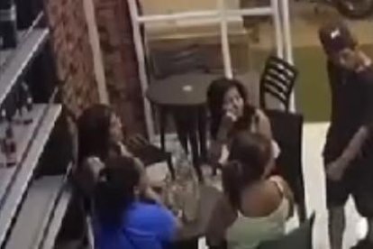 El tipo se acerca a las mujeres mientras estaban sentadas dentro del bar.