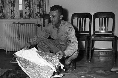 En el Campo Aéreo del Ejército de Fort Worth, el Mayor Jesse A. Marcel de Houma, Luisiana (mirando a la derecha) y sosteniendo un trozo de material forrado con papel de aluminio relacionado con Roswell, Nuevo México, incidente OVNI, 08/07/1947