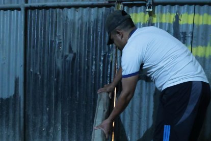 José se asegura poniendo troncos en el cerramiento de su casa.