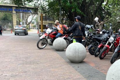 Entrada de la puerta G1 con motos parqueadas a las afueras de la universidad.