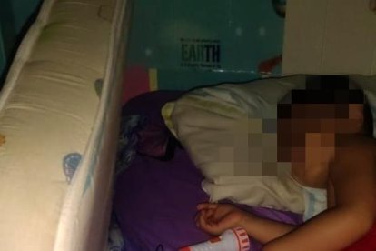 Un niño duerme con una linterna encendida.