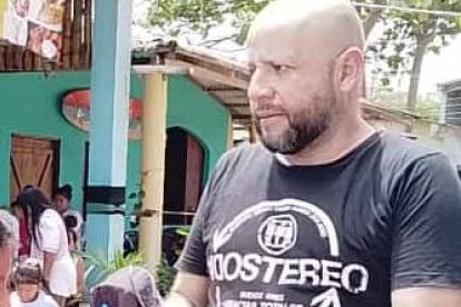 El gestor cultural Harold Mera entrega una mochila a una niña.