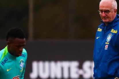 AME6209. CURITIBA (BRASIL), 05/09/2024.- El entrenador Dorival Junior (d) y Vinícius Jr de la selección brasileña de fútbol, participan en un entrenamiento en el Centro Administrativo y Técnico Alfredo Gottardi (CAT do Caju), este jueves, en la ciudad de Curitiba, Paraná (Brasil). El próximo viernes (6) la selección brasileña se enfrentará a la selección de Ecuador en la eliminatoria para el Mundial de Fútbol de 2026. EFE/ André Coelho.