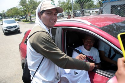 Romario Caicedo (der.) lateral y capitán azul, estampa su firma a la salida del Polideportivo de Samanes.