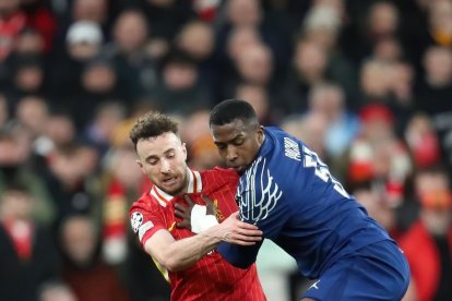 Wllian Pacho (d) en la marca sobre un jugador de Liverpool, en el partido de PSG en Anfield, por los octavos de final de Champions League