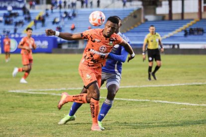 Jugador de Libertad protege la pelota ante el acecho de un futbolista de Emelec.