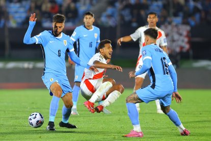 Rodrigo Bentancur (i) de Uruguay disputa el balón con Christofer Gonzáles (c), en un partido por las eliminatorias a la Copa Mundial 2026 .