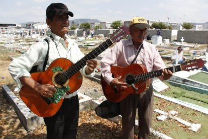 Con guitarras y cantantes se rinde tributo a los difuntos en su día.