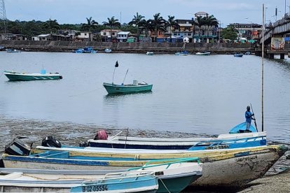 Zona del Relleno en Muisne, donde las lanchas pesqueras conviven con la cotidianidad ribereña bajo el puente urbano.