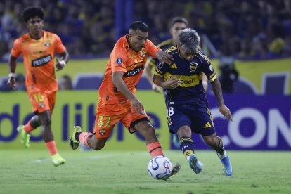 Milton Delgado (d) de Boca disputa el balón con Matías Lugo de Barcelona.