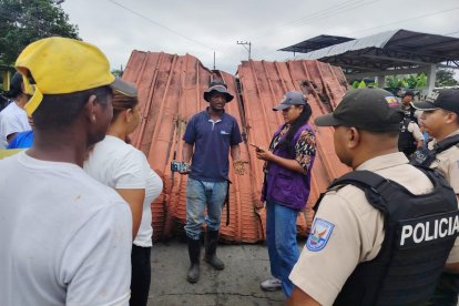 Policías dialogan con moradores de Palma Real junto a láminas metálicas usadas para bloquear la vía E20, en medio de la protesta comunitaria por obras incumplidas.
