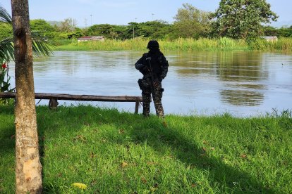 Un agente armado vigila la ribera del río Esmeraldas, en labores de control tras el hallazgo de un cuerpo en el sector El Cabezón.