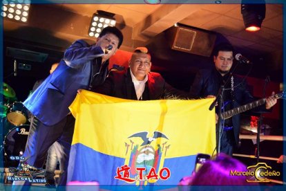 El compatriota, durante una presentación, mostrando con orgullo la bandera ecuatoriana.