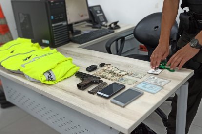 Las evidencias halladas a los detenidos. El arma estaba escondida entre los chalecos.