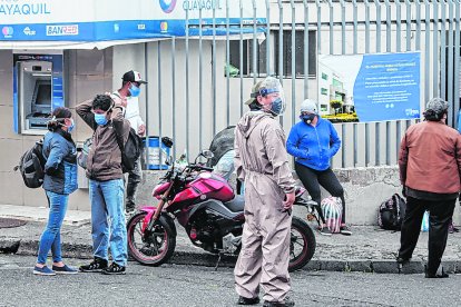 La gente llega a la entrada del hospital para conocer noticias de sus parientes.