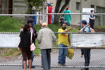 En el Hospital Enrique Garcés, en el sur de la capital, los familiares de los pacientes con coronavirus esperan información afuera.