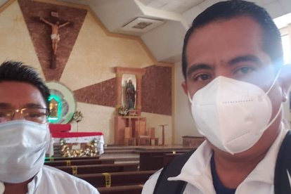 El monseñor Dustín Salazar que oficializará la misa de Dannes Coronel ,coordina con Antonino Solano de la Aso de emelecistas de Naranjal los detalles de la misa.