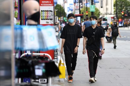 Peatones con mascarillas que transitan por las tiendas en Oxford Street en Londres, Gran Bretaña.