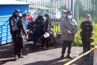 Familiares de una adulta mayor que falleció en el hospital Enrique Garcés, en el sur de la capital, esperan el cadáver en las afueras del centro.