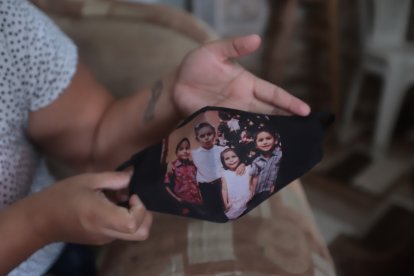 La madre guayaquileña sostiene una mascarilla que tiene la fotografía de la última Navidad que pasó con su hijo Maxiliniano.