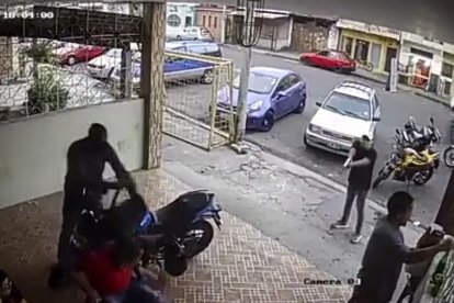 Uno de los delincuente toma la mochila donde uno de los perjudicados guardaba una lapto.