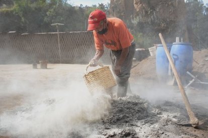 La ceniza del horno es colocada en el barro para compactar la mezcla.