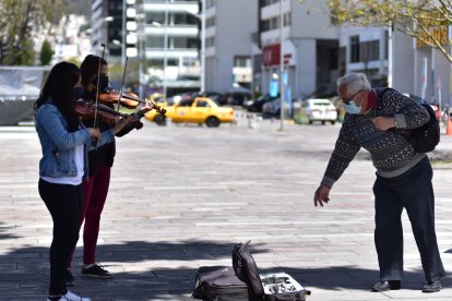 La gente que aprecia el arte apoya con una moneda a las dos chicas de nacionalidad venezolana.