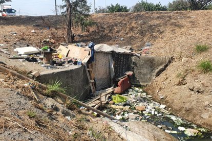 Este canal  de aguas residuales está rodeado de maleza y basura. En el lugar también hay roedores, insectos y culebras. En estas condiciones viven cuatro desafortunados hombres.