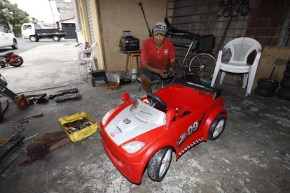 Repara los coches infantiles en el portal de su vivienda, en el suburbio de Guayaquil. También arregla motos lineales.