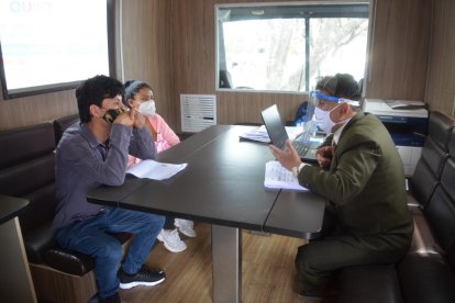 Un defensor público atiende a una pareja dentro de una de las oficinas móviles.