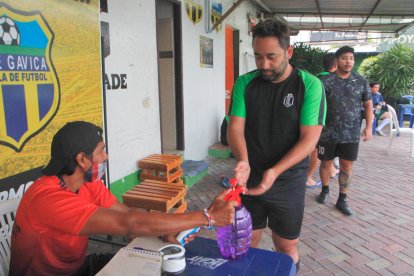 Antes de ingresar a la cancha, a cada persona se le toma la temperatura y se le rocía alcohol en las manos.