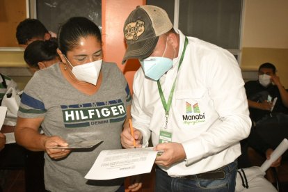 Un funcionario de la Prefectura hace el registro de una beneficiaria del plan de ayuda alimentaria.