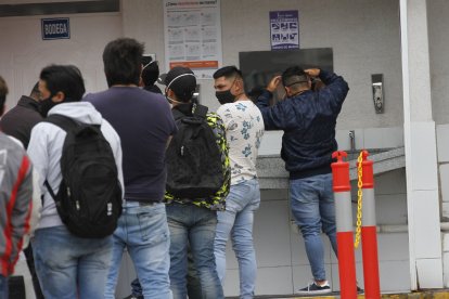 Decenas de  clientes hacen fila para pasar por los controles de bioseguridad.