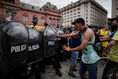 Un grupo de personas choca con la policía durante la espera para poder ingresar al velatorio.
