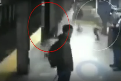 Captura de la escena en la cual el indigente calcula el momento en que decide lanzar a la mujer en los rieles.