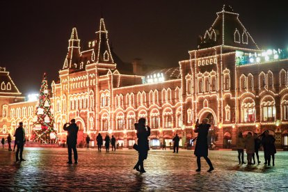 Rusos caminan frente a la Tienda del Departamento de Estado (GUM) decorada para Navidad y Año Nuevo en la Plaza Roja en Moscú.