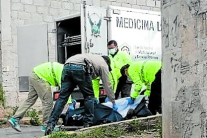 Policías levantan el cadáver del extranjero asesinado a golpes.