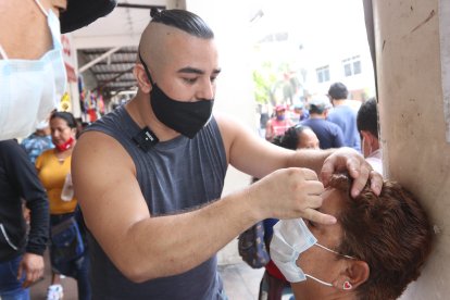 Con sumo cuidado y gran higiene, Duvier depila las cejas de su clienta de paso.