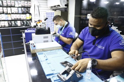 Los chamos Édgar Caballero e Isaac Mujica se dedican al mantenimiento de celulares.