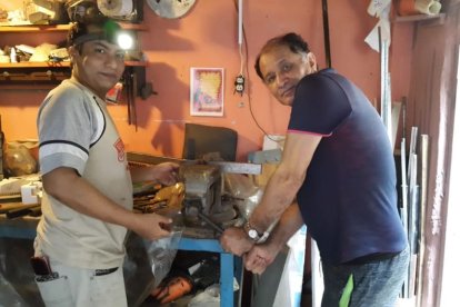 Leonardo (izq.) y René trabajando en el prototipo del ‘bicitren’.