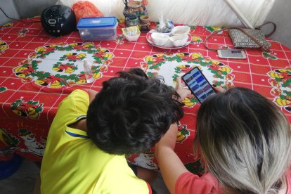 María hace repasar a su hijo los contenidos que le enseñaron el año anterior.