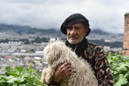 Desde su vivienda se puede apreciar el sur de Quito. En la foto, el hombre carga a Linda Flor.