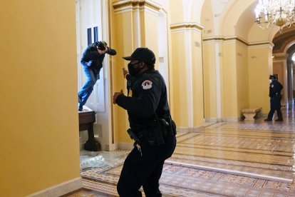 La policía repele a uno de los manifestantes.