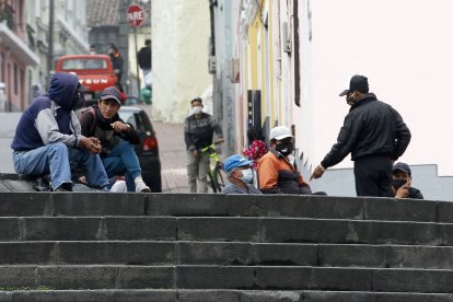 Varios hombres esperan por un ‘cachuelo’ de oficios como albañilería o plomería.