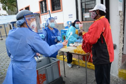Personas reciben el alimento en el parqueadero del albergue. Cuando no llueve comen allí mismo.