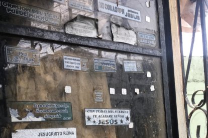 En la ventana de la casa aparecen pegados sticker de fe.