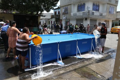 Moradores ayudaban a sacar el agua con tachos y baldes.