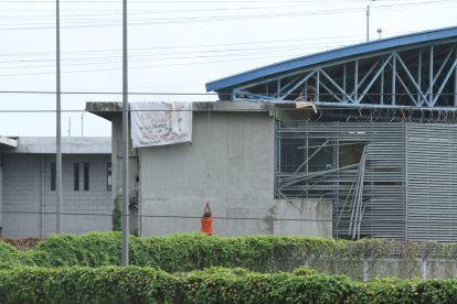Instantes en un recluso intenta fugarse. En la misma pared cuelga una pancarta hecha por internos.